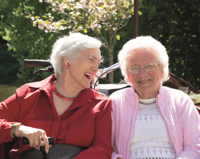 Two elderly ladies sat together outside